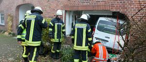 Feuerwehrleute bergen am Montag in Holtum-Geest (Niedersachsen) einen Kleinbus, der bei einem Unfall die Außenwand eines Wohngebäudes durchbrochen hat und in der Küche landete. Nach Angaben eines Polizeisprechers wurden der Fahrer und Beifahrer leicht verletzt. Die Bewohner waren beim Unfall nicht in der Küche.