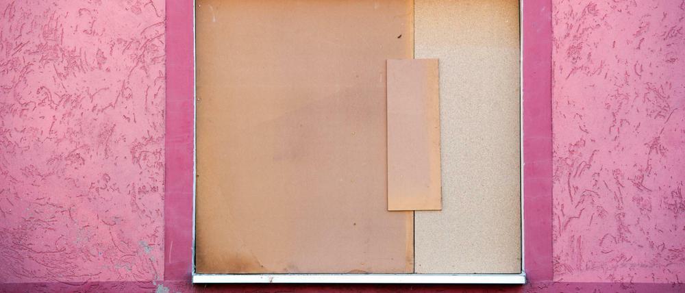 Ein Holzplatte ist vor einem Fenster einer Asylbewerberunterkunft in Freital angebracht. Bei einem Anschlag auf eine Wohnung von Asylbewerbern ist in Freital ein Mensch leicht verletzt worden.