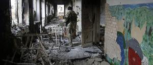 Ein ukrainischer Soldat in einer zerstörten Schule im Dorf Pisky in der Nähe der ostukrainischen Stadt Donezk. Nach UN-Angaben wurden in der Ostukraine etwa 200 Schulen bei den Kämpfen zerstört oder beschädigt.