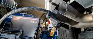 Abgasuntersuchung im Auspuffrohr eines VW Golf in einer Werkstatt in Frankfurt (Oder).
