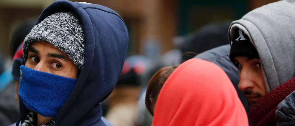 Die Augen bleiben frei: Flüchtlinge schützen sich vor dem Berliner Landesamt für Gesundheit und Soziales vor der Kälte.