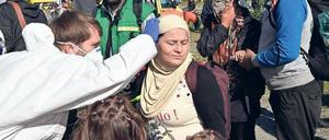 Erste Hilfe. Ein Mediziner des Deutschen Roten Kreuzes untersucht am Bahnhof Schönefeld eine Frau aus Syrien, die mit dem Zug aus München angekommen ist.