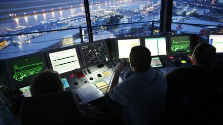 Fluglotsen der Deutsche Flugsicherung (DFS) regeln am Montag (24.01.2011) im Tower des Flughafens Düsseldorf den Luftverkehr. In der Nacht zu Montag, während der Flugbetrieb ruht, wird am Flughafen Düsseldorf nach Bombenblindgängern gesucht. Der Verdacht hatte sich bei Sondierungsarbeiten ergeben.