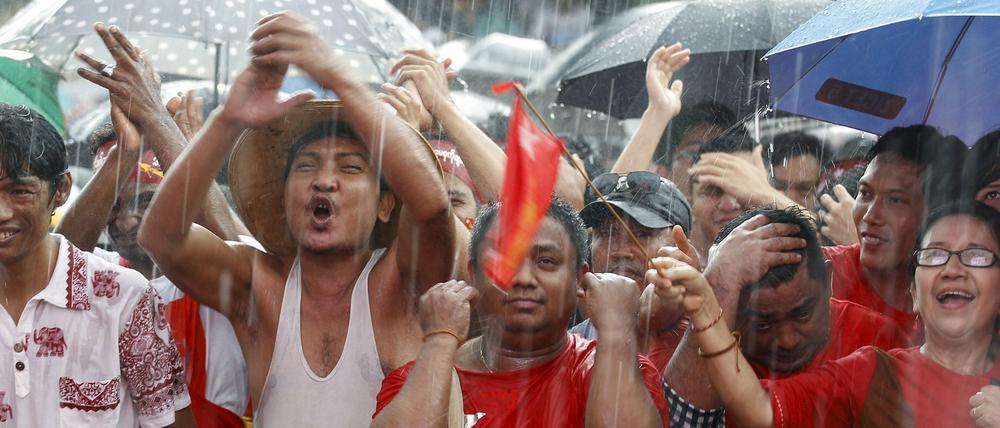 Freude im Regen. Anhänger von Aung San Suu Kyis Oppositionspartei NLD feiern die ersten Teilergebnisse der Parlamentswahl in Myanmar. 