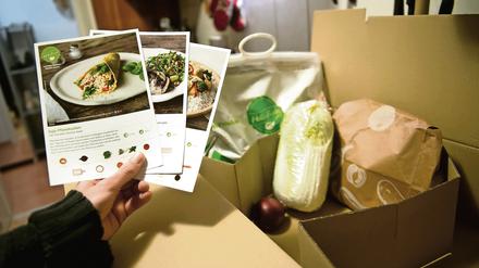 Ein Mann hält mitgelieferte Kochrezepte aus einer HelloFresh Kochbox in der Hand. 