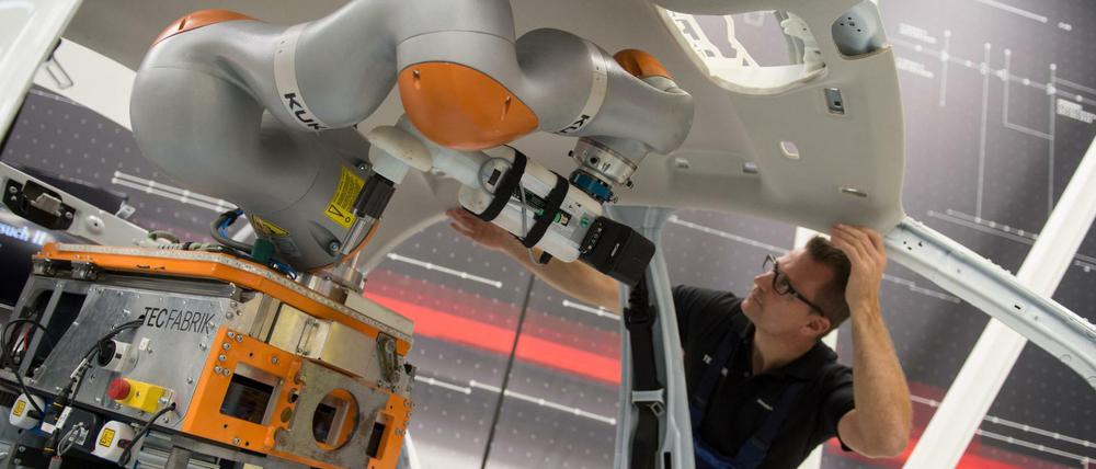 Mensch und Roboter arbeiten zusammen. Das ist ein Merkmal der Digitalisierung in der Industrie.
