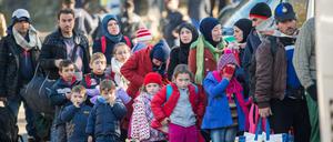 ARCHIV - Flüchtlinge gehen am 03.11.2015 von der Notunterkunft nahe der oberösterreichischen Ortschaft Hanging (Österreich) auf die deutsche Seite Richtung Wegscheid (Bayern/Deutschland) zu einem bereitgestellten Bus. Foto: Peter Kneffel/dpa (zu dpa "«Wirtschaftsweise»: Kosten für Flüchtlinge tragbar" vom 11.11.2015) +++(c) dpa - Bildfunk+++