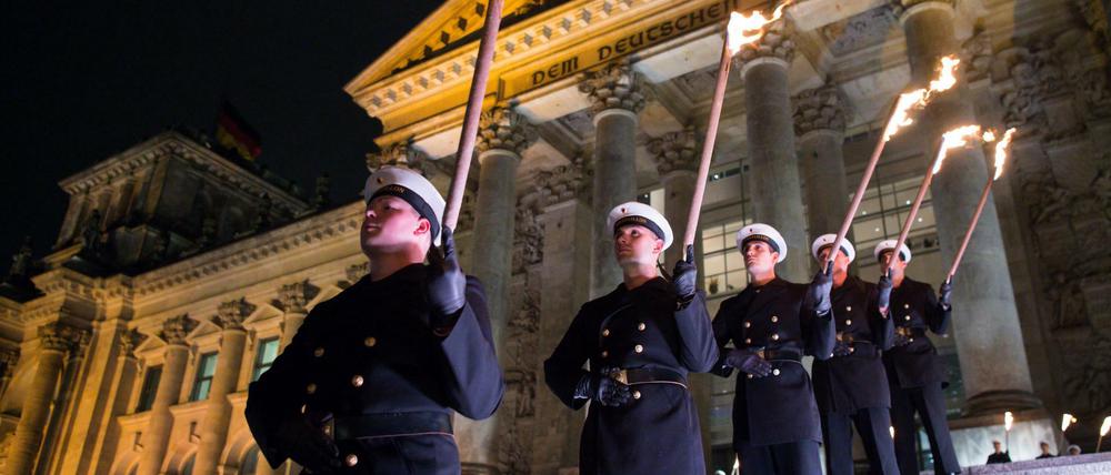 Zahlreiche Soldaten stehen bei dem Großen Zapfenstreich vor dem Reichstagsgebäude in Berlin.