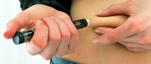 Eine Diabetikerin spritzt sich mit einem Insulin-Pen Insulin.