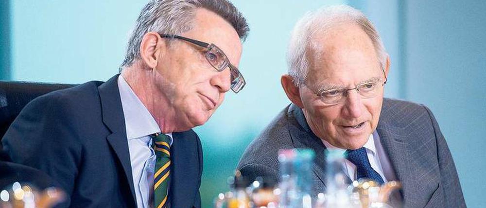 Kritiker unter sich. Innenminister Thomas de Maizière (l.) und Finanzminister Wolfgang Schäuble beraten sich vor einer Sitzung des Bundeskabinetts.