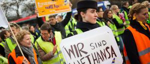 Eine Lufthansa-Mitarbeiterin hält in Frankfurt am Main bei einer Kundgebung vor Konzernzentrale der Fluggesellschaft am Flughafen ein Plakat mit der Aufschrift "Wir sind Lufthansa". 