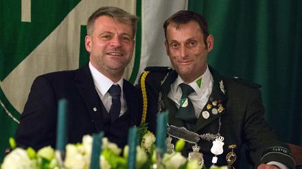 Udo Figge (r), König der Bilker Schützen, sitzt am 03.10.2015 mit seinem Ehemann Dirk Jehle (l) während der Krönungsfeier in Düsseldorf am Tisch. Ein schwules Schützenkönigspaar hatte nicht jedem gefallen. Trotzdem hat sich der Dachverband der Schützen nun zu mehr Offenheit bekannt. 