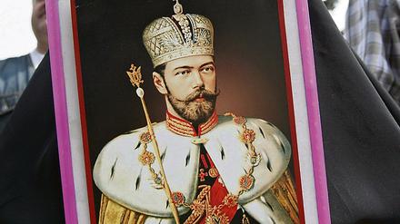 Eine Frau mit dem Porträt des letzten russischen Zaren Nikolai II. Seit dem Fund der Knochen in Jakaterinburg im Ural schwelt in Russland die Debatte um deren Echtheit.