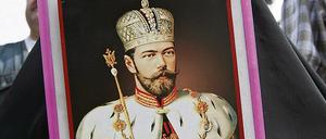 Eine Frau mit dem Porträt des letzten russischen Zaren Nikolai II. Seit dem Fund der Knochen in Jakaterinburg im Ural schwelt in Russland die Debatte um deren Echtheit.