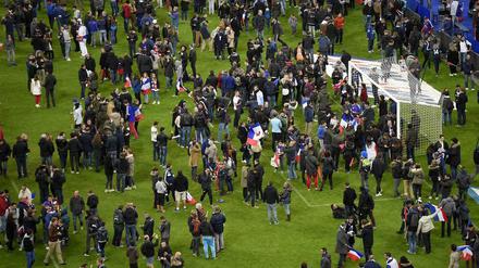 Der Rasen im Fußballstadion von St. Denis als Zufluchtsstätte für Fans und Medienvertreter.