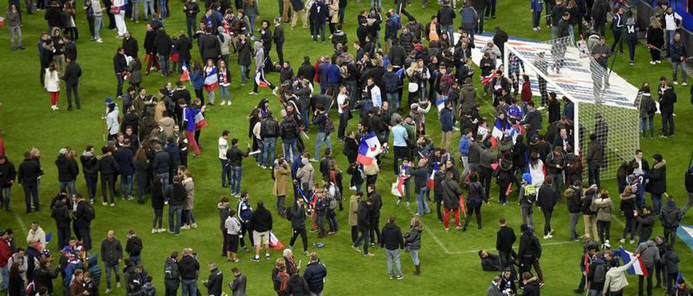 Der Rasen im Fußballstadion von St. Denis als Zufluchtsstätte für Fans und Medienvertreter.