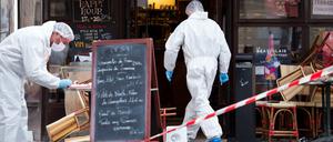 Polizisten in Schutzanzügen sichern am Samstag vor dem Cafe Comptoir Voltaire in Paris Spuren. 