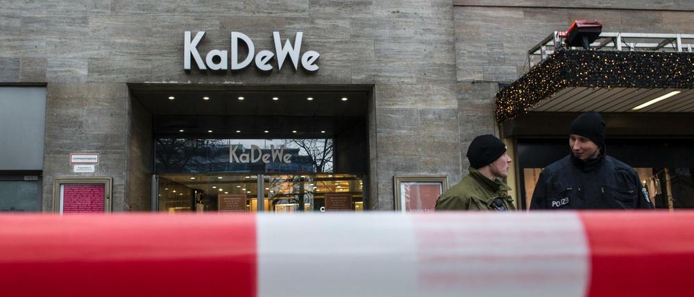 Polizisten stehen am 20.12.2014 in Berlin vor dem Kaufhaus KaDeWe hinter einer Absperrung.