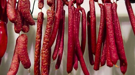 Rotes Verhängnis. Landjäger-Würstchen hängen im Laden einer Fleischerei.