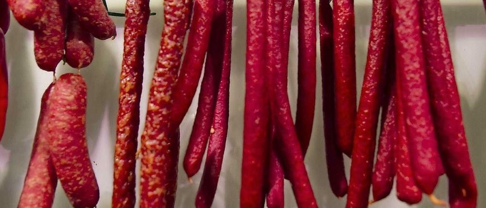 Rotes Verhängnis. Landjäger-Würstchen hängen im Laden einer Fleischerei.