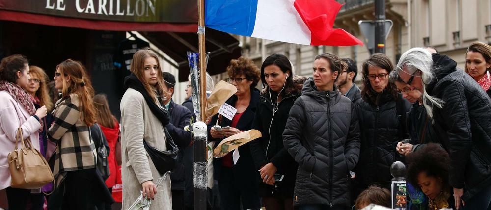 Trauernde versammeln sich vor den Restaurants "Le Petit Cambodge" and "Le Carillon" in Paris. 