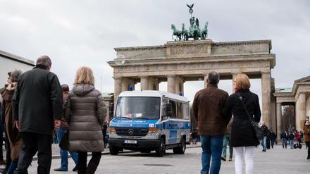 Ein Mannschaftswagen der Berliner Polizei steht vor dem Brandenburger Tor. 