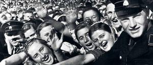 Zehntausende können irren. Vertreter der „Volksgemeinschaft“ bejubeln Hitler beim „Reichserntedankfest“ am Bückeberg, vermutlich am 6. Oktober 1935, von SS-Männern mit Toten-Kopf-Mützen in Schach gehalten. 