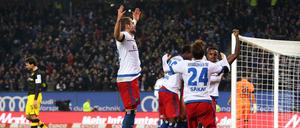 Hamburgs Spieler freuen sich über das Eigentor von Dortmunds Mats Hummels (l) zum 3-0. 