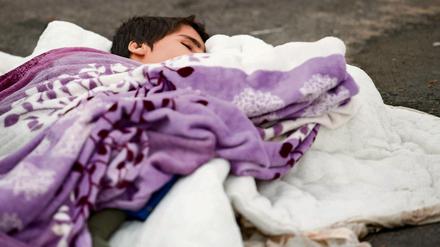 Für die Kinder ist es besonders hart. Ein Flüchtlingskind aus Syrien schläft hier auf dem Boden in einem Zelt auf dem Gelände des Landesamtes für Gesundheit und Soziales (Lageso) in Berlin. Unbegleitete Minderjährige kommen aber noch nicht mal mit Eltern an, die ihnen eine Decke ausbreiten. 