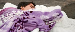 Für die Kinder ist es besonders hart. Ein Flüchtlingskind aus Syrien schläft hier auf dem Boden in einem Zelt auf dem Gelände des Landesamtes für Gesundheit und Soziales (Lageso) in Berlin. Unbegleitete Minderjährige kommen aber noch nicht mal mit Eltern an, die ihnen eine Decke ausbreiten.