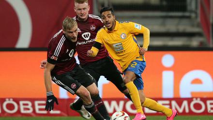 Die Nürnberger Hanno Behrens (links) und Sebastian Kerk sowie Braunschweigs Salim Khelifi haben den Ball im Blick. 