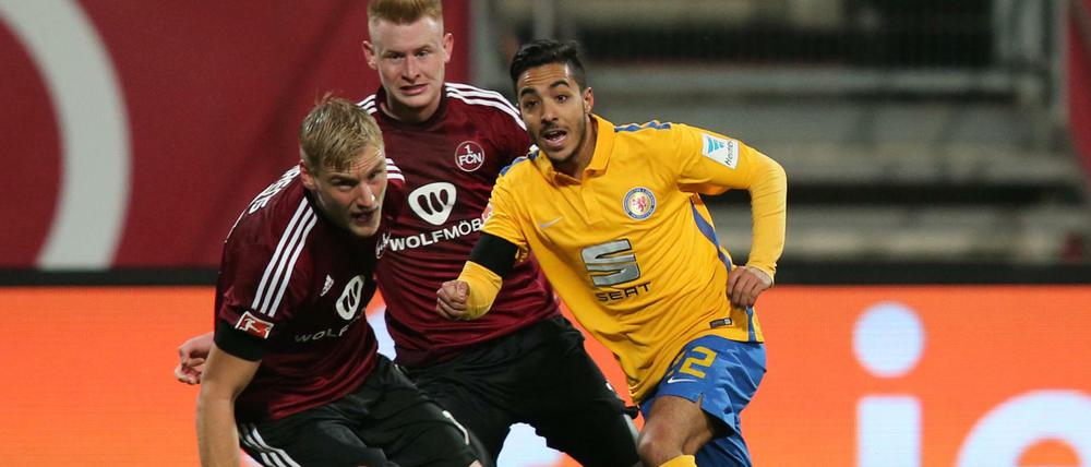 Die Nürnberger Hanno Behrens (links) und Sebastian Kerk sowie Braunschweigs Salim Khelifi haben den Ball im Blick.