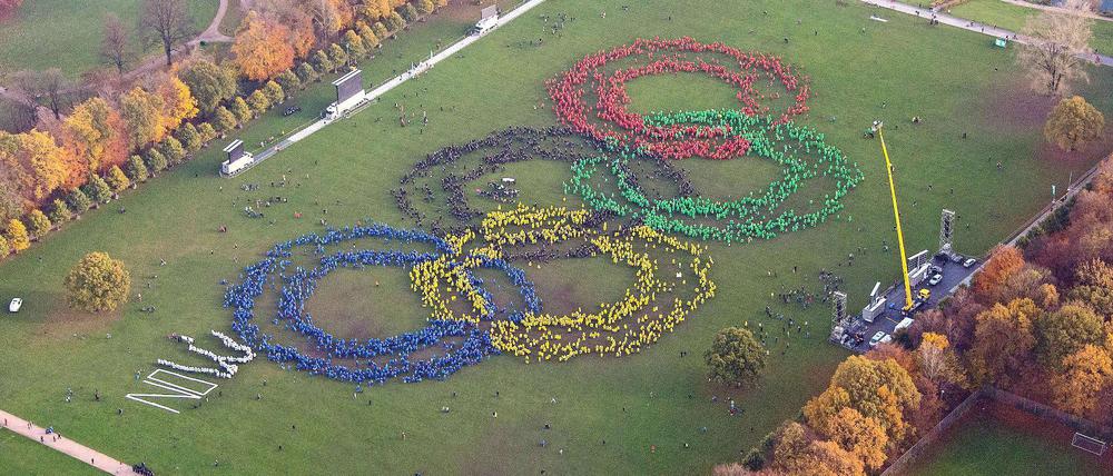 Wir wollen die Spiele. Mehrere Hundert Menschen bilden mit verschieden farbigen Ponchos am 08.11.2015 im Stadtpark in Hamburg die Olympischen Ringe. 