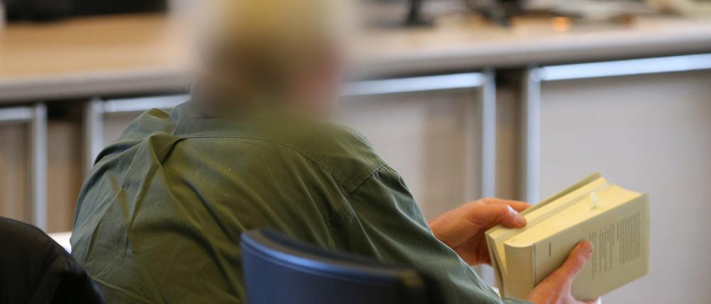 Klaus H. hält am 16.11.2015 im Amtsgericht Nördlingen (Bayern) während einer Verhandlungspause ein Gesetzbuch in seinen Händen. Das 54-jährige Mitglied der Glaubensgemeinschaft "Zwölf Stämme" ist der Misshandlung von Schutzbefohlenen und gefährlicher Körperverletzung angeklagt.