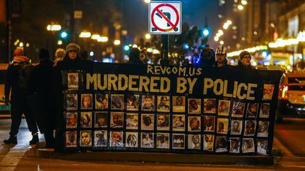 Demonstranten in Chicago halten am Dienstag ein Banner mit Bildern von angeblich von Polizisten ermordeten Schwarzen. 