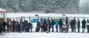 Flüchtlinge warten am Sonntag an der deutsch-österreichischen Grenze nahe Hanging (Österreich) im Schnee vor einem beheizten Zelt. Die Anzahl der Flüchtlinge nach Deutschland wird im November einen neuen Rekord erreichen.