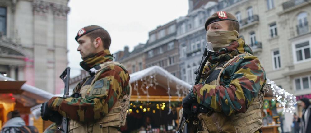 Die Terrorwarnstufe ist um eine Stufe heruntergesetzt worden, doch in Brüssel patrouillieren noch immer schwer bewaffnete Sicherheitskräfte - hier auf einem Weihnachtsmarkt.