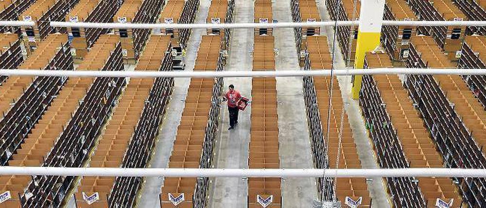 Allein auf schmaler Flur stellt ein sogenannter „Picker“ in Brieselang (Kreis Havelland) im Lager des Amazon-Logistikzentrums die Bestellungen zusammen. Foto: Bernd Settnik/dpa