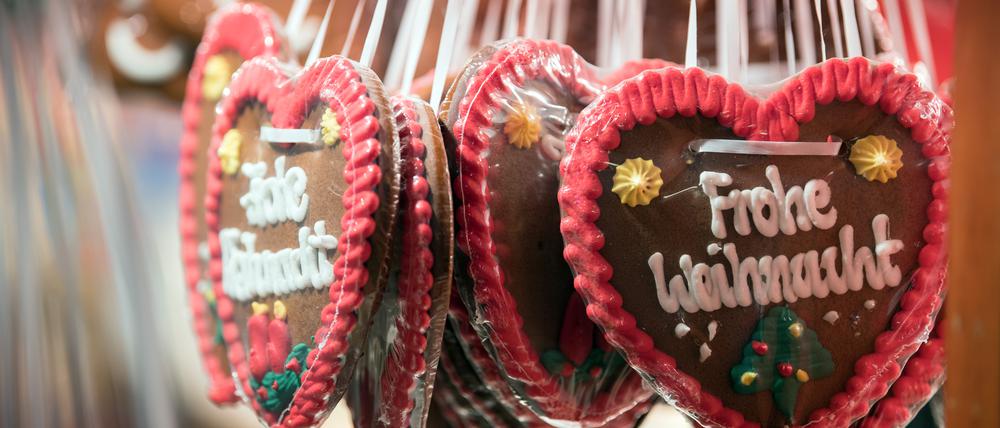 Lebkuchen-Herzen mit der Aufschrift „Frohe Weihnacht“ hängen an einem Stand auf dem Weihnachtsmarkt in der Altstadt von Spandau. 