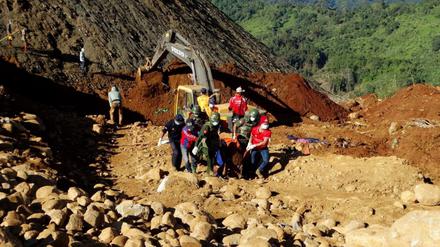 Soldaten und Hilfskräfte in Myanmar ziehen den toten Körper eines Arbeiters aus den Erdmassen. Bei dem Erdrutsch kamen bisher 110 Menschen ums Leben. 