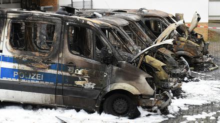 Ausgebrannte Polizeifahrzeuge stehen am Dienstag in Bremen auf dem Parkplatz einer Polizeistation.