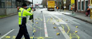 Ein Lastwagen mit einem beschädigten Anhänger steht nach einem Zusammenstoß mit einem Bus am 02.12.2015 hinter Polizeimarkierungen am Tierpark in Berlin