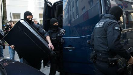 Vermummte Polizisten tragen nach der Durchsuchung eines Objektes in Düsseldorf (Nordrhein-Westfalen) einen Server in einen Van. 