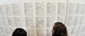 Zwei Jugendliche stehen in Halle vor einer Wand mit Job- und Lehrstellenangeboten.