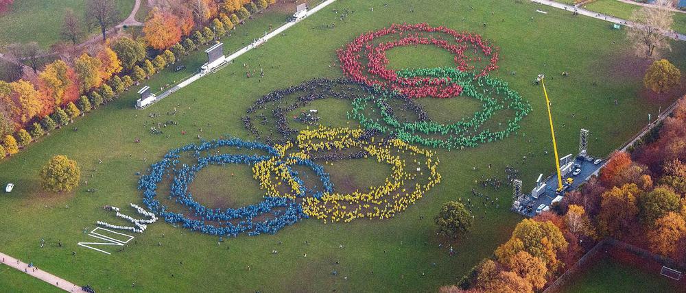 Mehrere Hundert Menschen bilden mit verschieden farbigen Ponchos am 8.11.2015 im Stadtpark in Hamburg die Olympischen Ringe im Rahmen der Olympia-Initiative "Feuer und Flamme für Hamburg 2024" nach. Am Sonntag entscheiden die Bürger in Hamburg und Kiel in einem Referendum, ob sich die Hansestadt Hamburg um Olympische Spiele 2024 bewerben soll. 