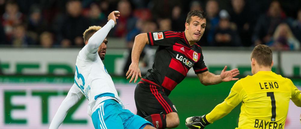 Schalkes Eric Maxim Choupo-Moting (l) erzielt im Zweikampf gegen Leverkusens Giulio Donati (m) und Leverkusens Torwart Bernd Leno (r) das Tor zum 0:1.