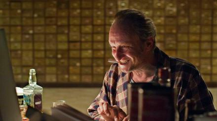 In seinem Element: Gott (Benoit Poelvoorde) mit Alkohol und Zigaretten in "Das Brandneue Testament"