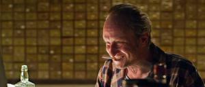 In seinem Element: Gott (Benoit Poelvoorde) mit Alkohol und Zigaretten in "Das Brandneue Testament"