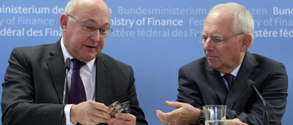 Frankreichs Finanzminister Sapin (links) veranschaulichte seinem deutschen Amtskollegen Schäuble, was es mit anonymen Prepaid-Bankkarten auf sich hat. 