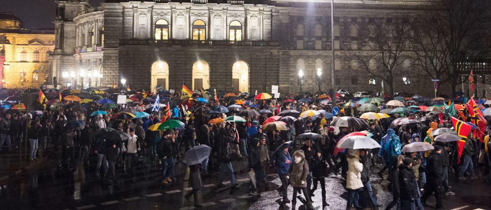 Die Teilnehmer gehen am 30.11.2015 während einer Kundgebung des Bündnisses Pegida (Patriotische Europäer gegen die Islamisierung des Abendlandes) in Dresden (Sachsen) an der Semperoper vorbei. 